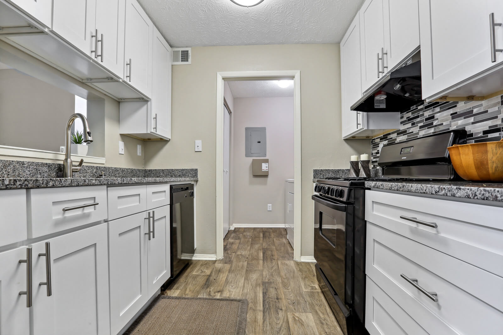 newly renovated kitchen with hardwood finish flooring and white cabinetry
