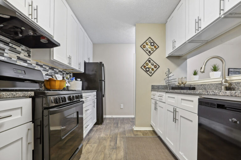 newly renovated kitchen with hardwood finish flooring and white cabinetry