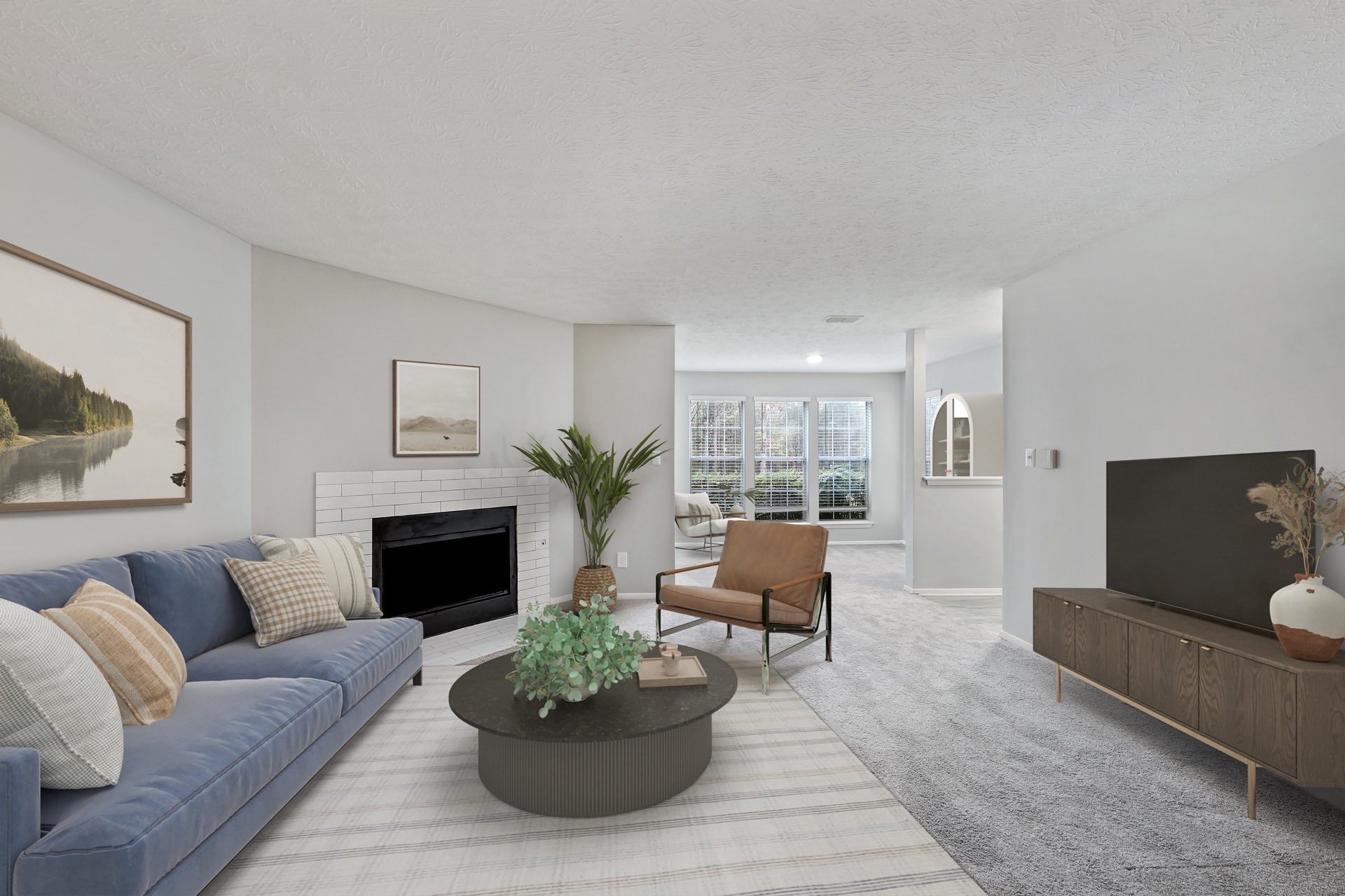 living room with plush carpeting, fire place, and ample lighting